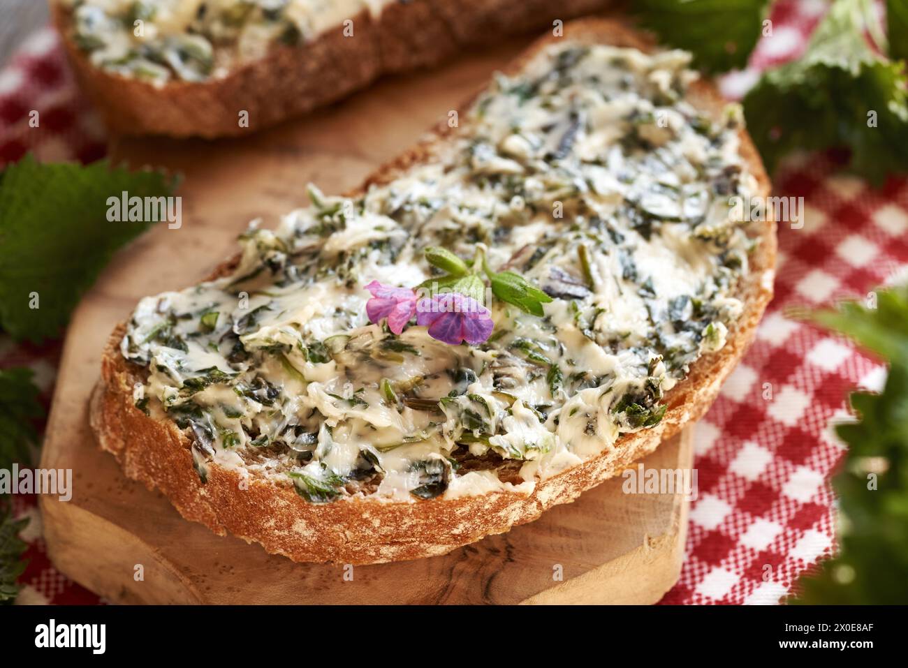 Burro di ortica - pane fatto in casa fatto di piante commestibili selvatiche raccolte in primavera su una fetta di pane a lievitazione naturale Foto Stock