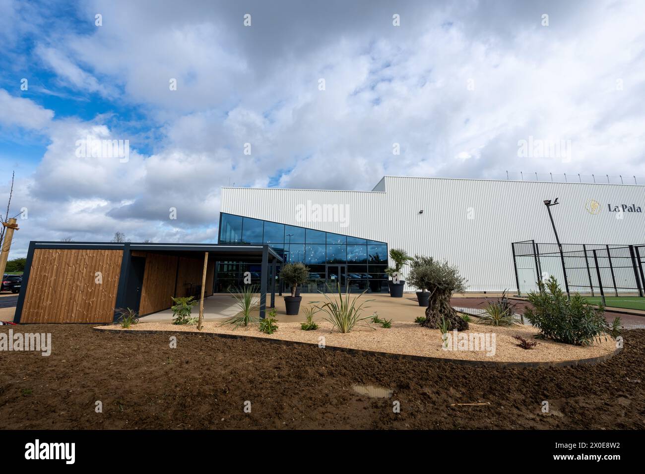 La costruzione di un moderno complesso sportivo con un enorme tetto in vetro e pergolato bioclimatico. L'edificio e' circondato da giardini Foto Stock