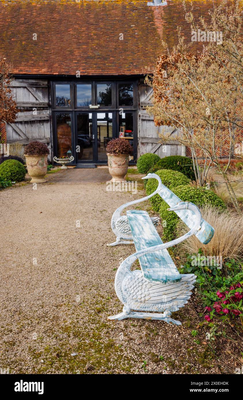 Elegante panca anticata a collo di cigno nel giardino di Bix Manor, Bix, vicino a Henley-on-Thames, nel sud dell'Oxfordshire Foto Stock