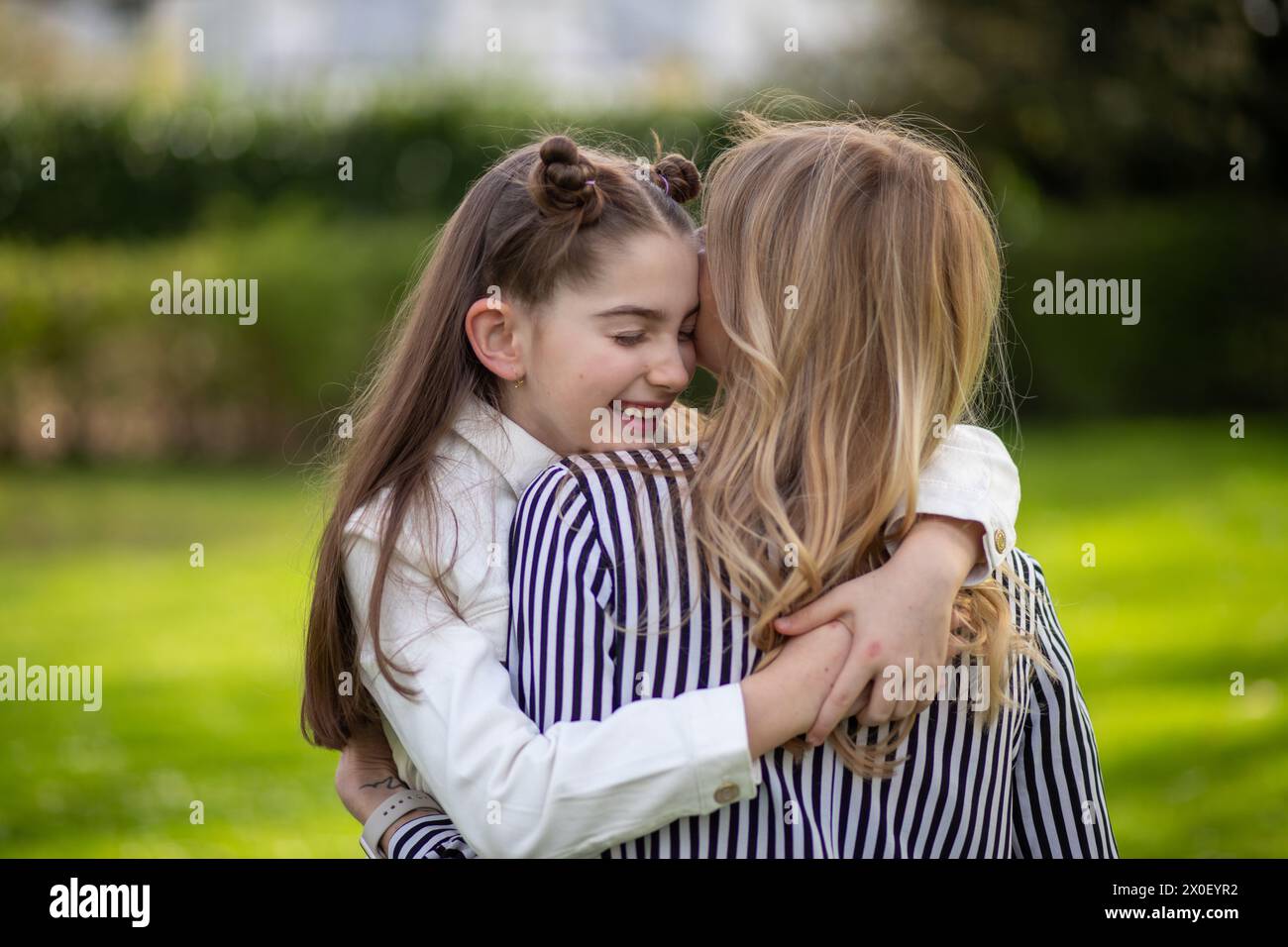 Madre e figlia abbracciano, figlia felice. Foto Stock