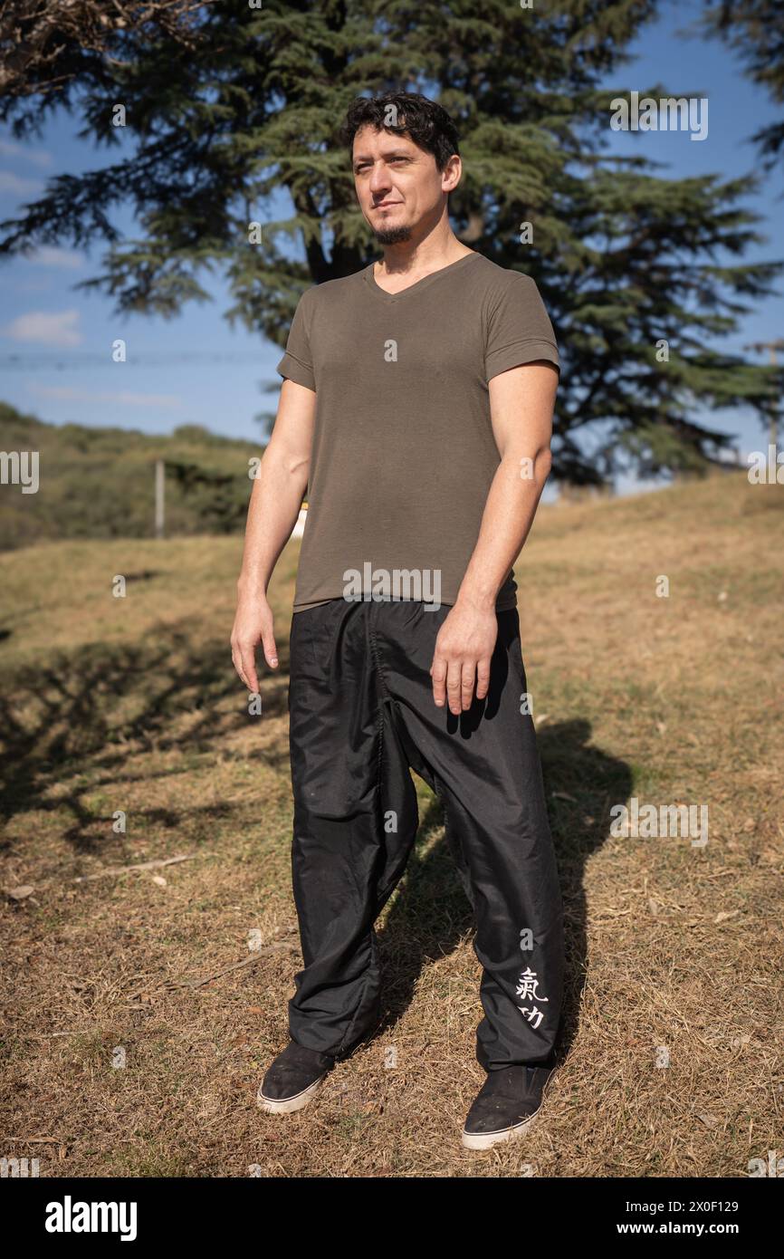 Un uomo all'aperto adotta la postura Wu chi, nota come "il vuoto", che segna l'inizio della sua sessione di allenamento qi gong o chi kung. Foto Stock