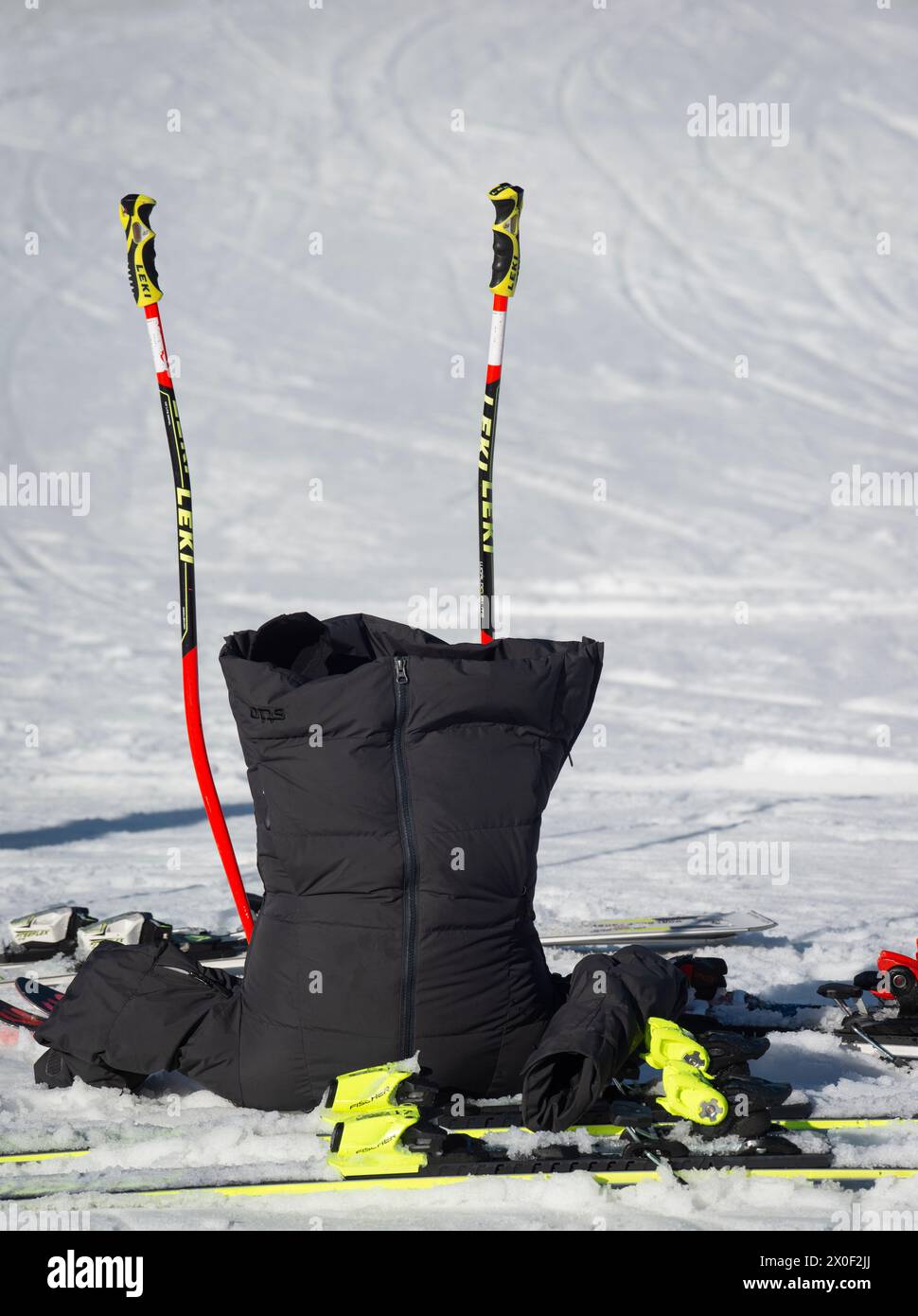 Attitash Mountain Resort, Bartlett, NH, Stati Uniti. Una giacca di riscaldamento da corsa si trova capovolta sulla neve con sci e pali vicino alla fine di una gara di sci alpino Giant Slalom del febbraio 2024 a Bear Peak. Foto Stock