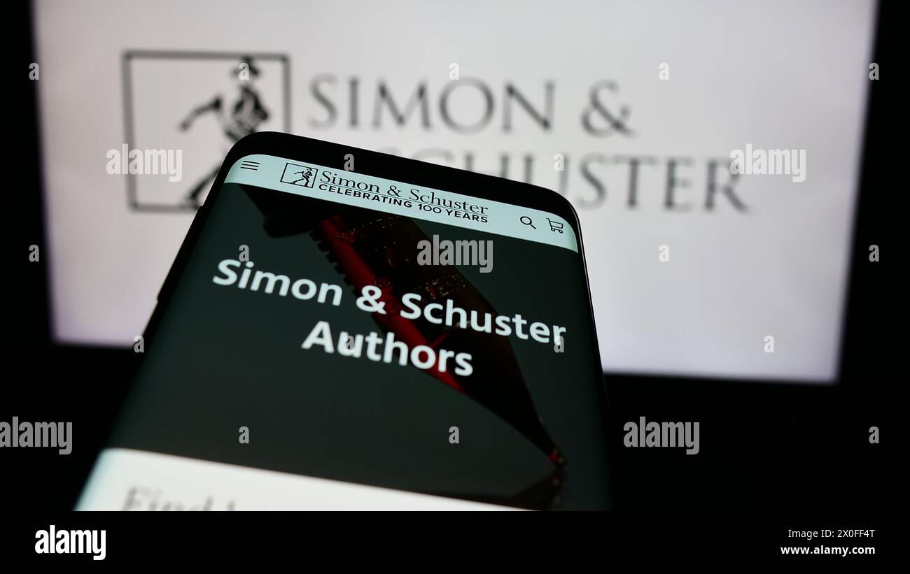 Telefono cellulare con sito web della casa editrice statunitense Simon and Schuster LLC davanti al logo aziendale. Mettere a fuoco in alto a sinistra sul display del telefono. Foto Stock