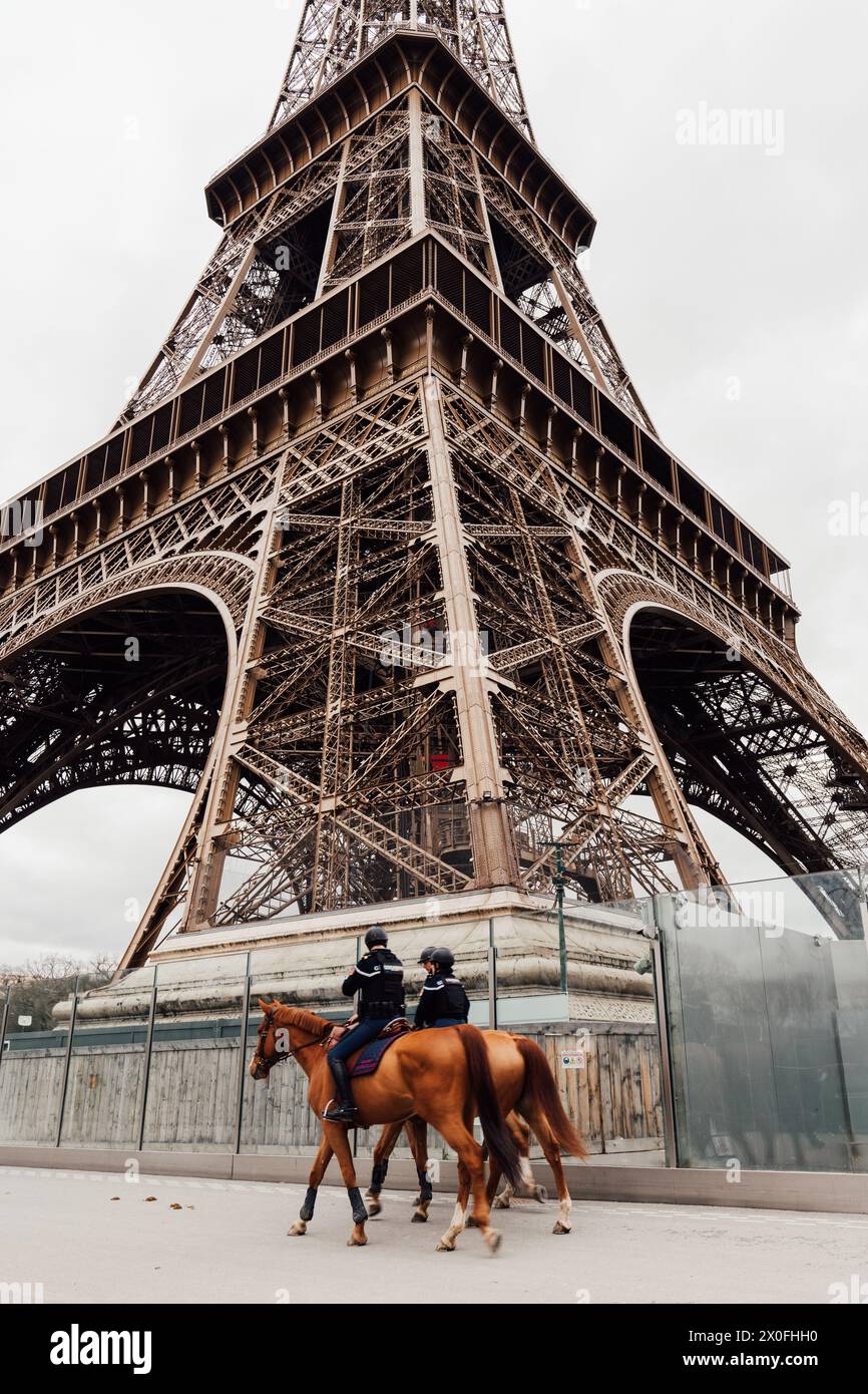 Coppia di polizia in cavalli che pattuglia la Torre Eiffel. Foto Stock