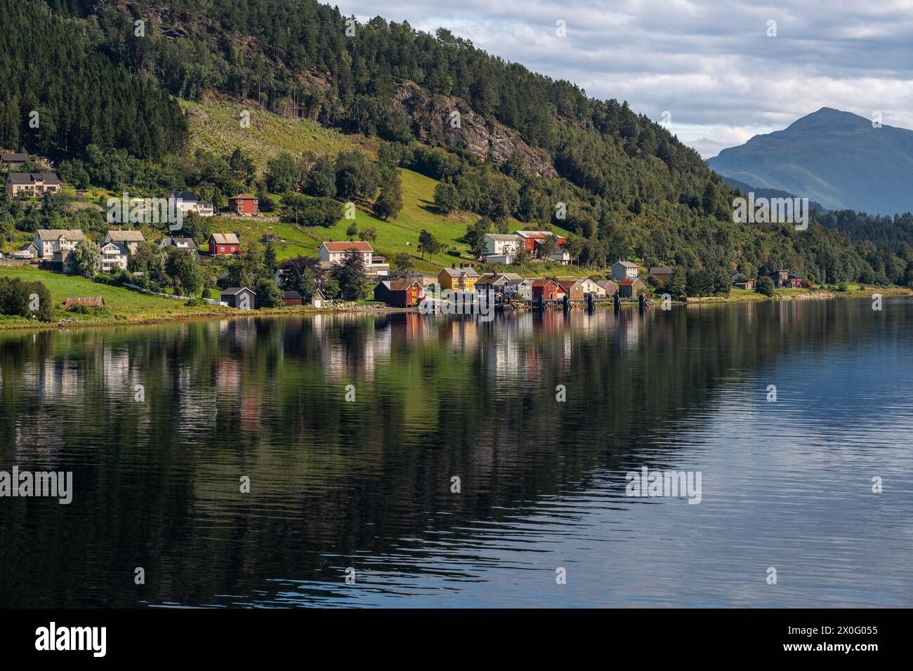 Una vista tranquilla del villaggio di Kvanne sulle rive dello Stangvikfjorden durante la tranquilla giornata estiva a Møre og Romsdal, destinazione di viaggio in Norvegia Foto Stock