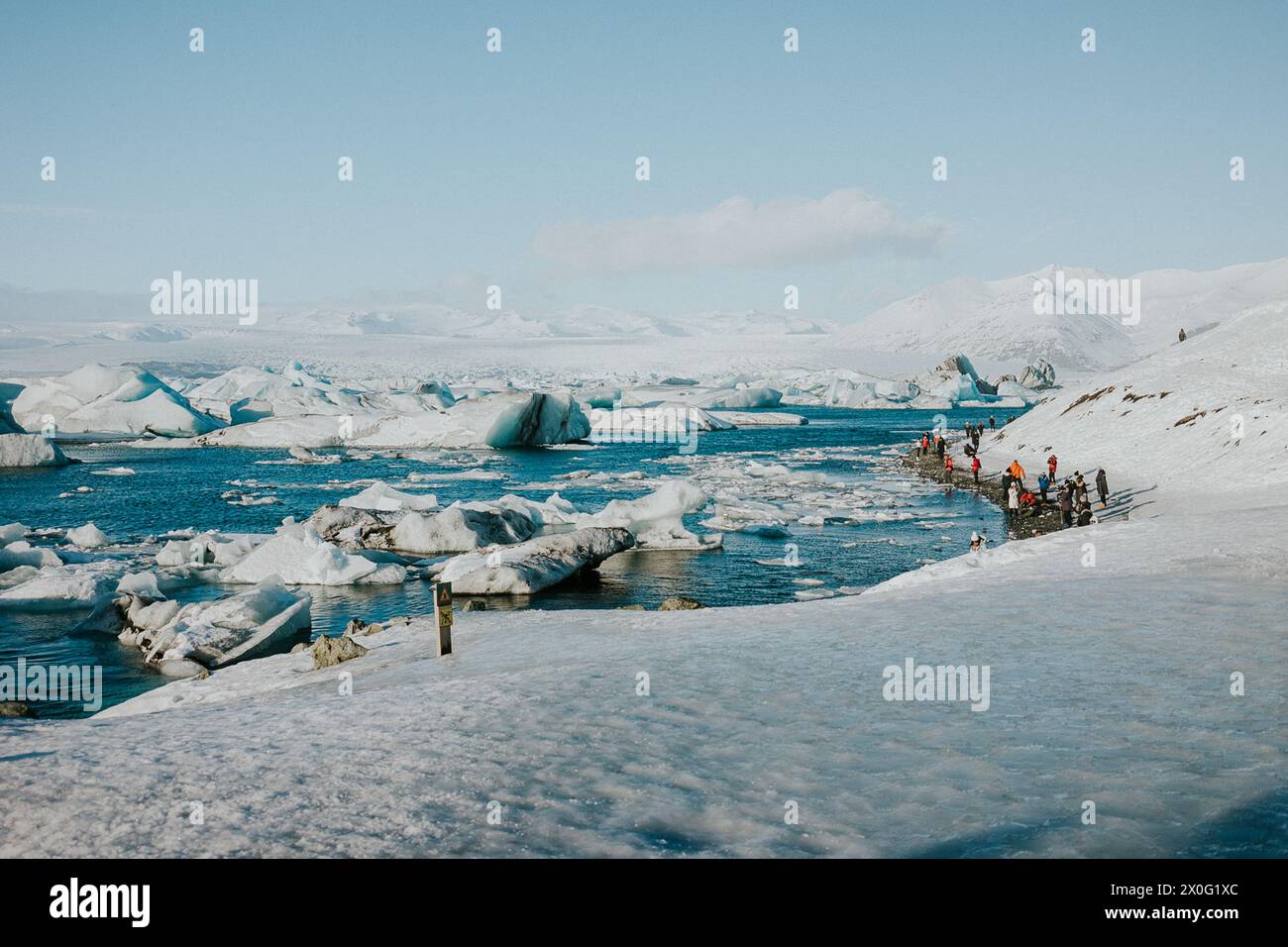La gente si riunisce ai margini della laguna glaciale del lago Jokulsarlon in Islanda Foto Stock