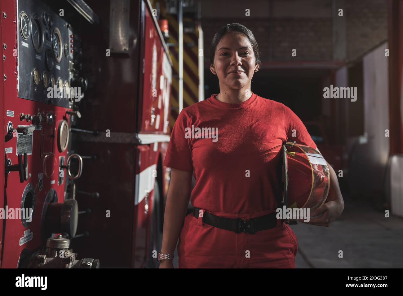 Ritratto di donna vigile del fuoco in piedi alla caserma dei pompieri Foto Stock