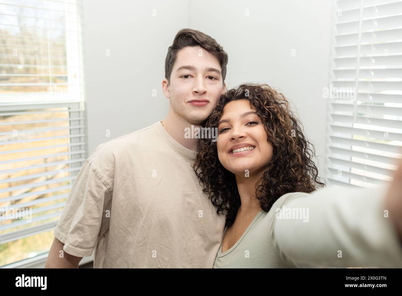 Un allegro selfie di coppia in una casa luminosa e accogliente Foto Stock