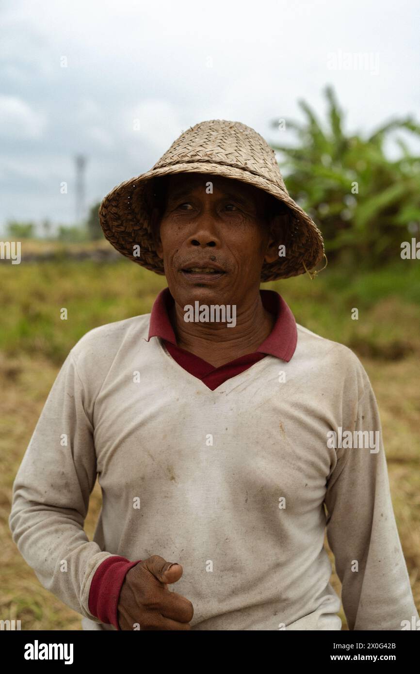 Un contadino locale balinese che indossa un cappello di paglia. Foto Stock