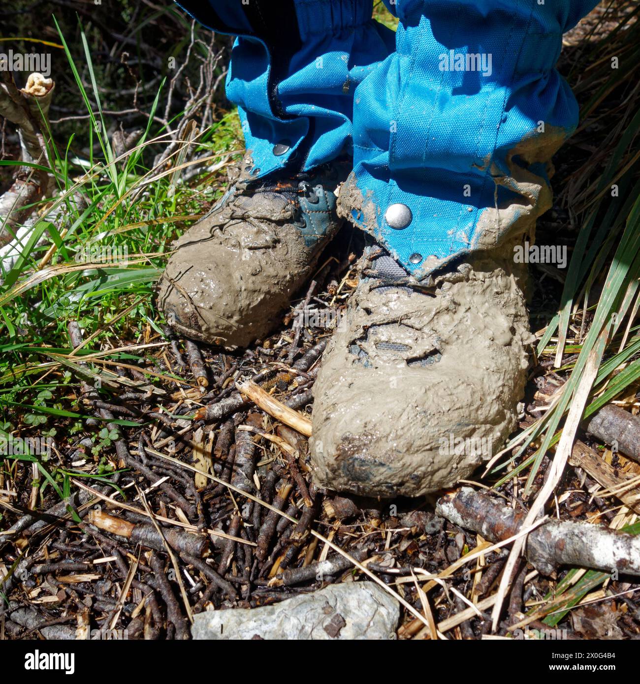 Una persona in piedi con stivali e ghette da trekking fangose, o putties come vengono chiamati in nuova Zelanda. Foto Stock