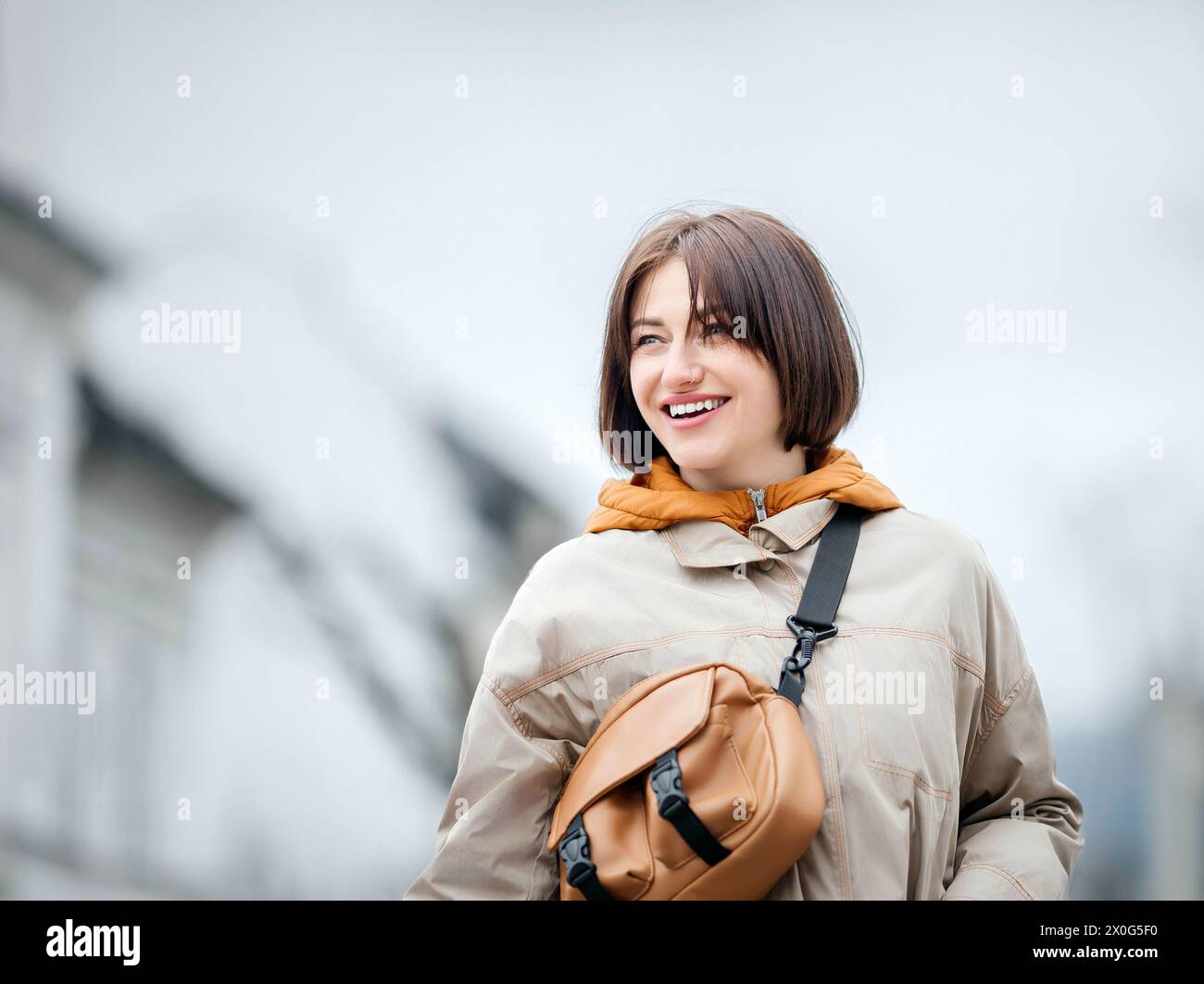 Donna elegante che si gode una giornata in città con uno zaino alla moda Foto Stock