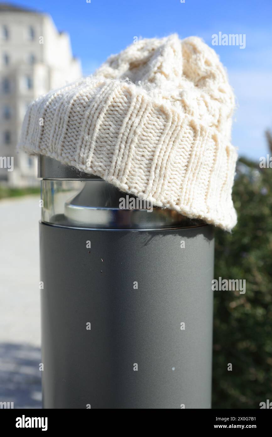 Cappello bianco in lana su un concetto post-riscaldamento, mantenimento dell'inverno caldo, costo del riscaldamento delle bollette energetiche di crisi Foto Stock