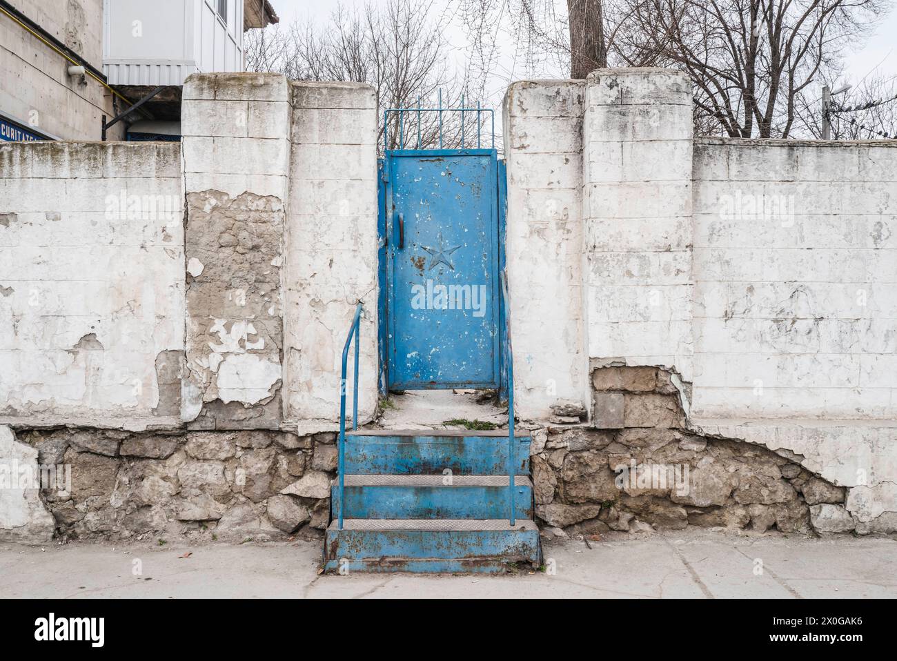 Una porta blu con una stella su un muro bianco. Chisinau. Chisinau. Capitale della Repubblica di Moldova nell'Europa orientale. Tra blocchi di arcaite in stile sovietico Foto Stock