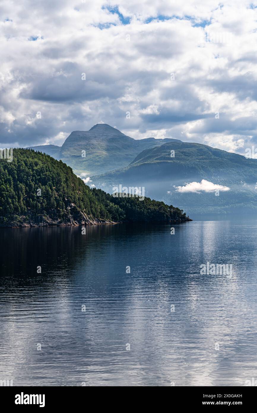 Serena vista del Monte Vardhaugen accanto al tranquillo Stangvikfjord sotto un cielo con basse nuvole sospese. Destinazione estiva per escursioni in Norvegia Foto Stock