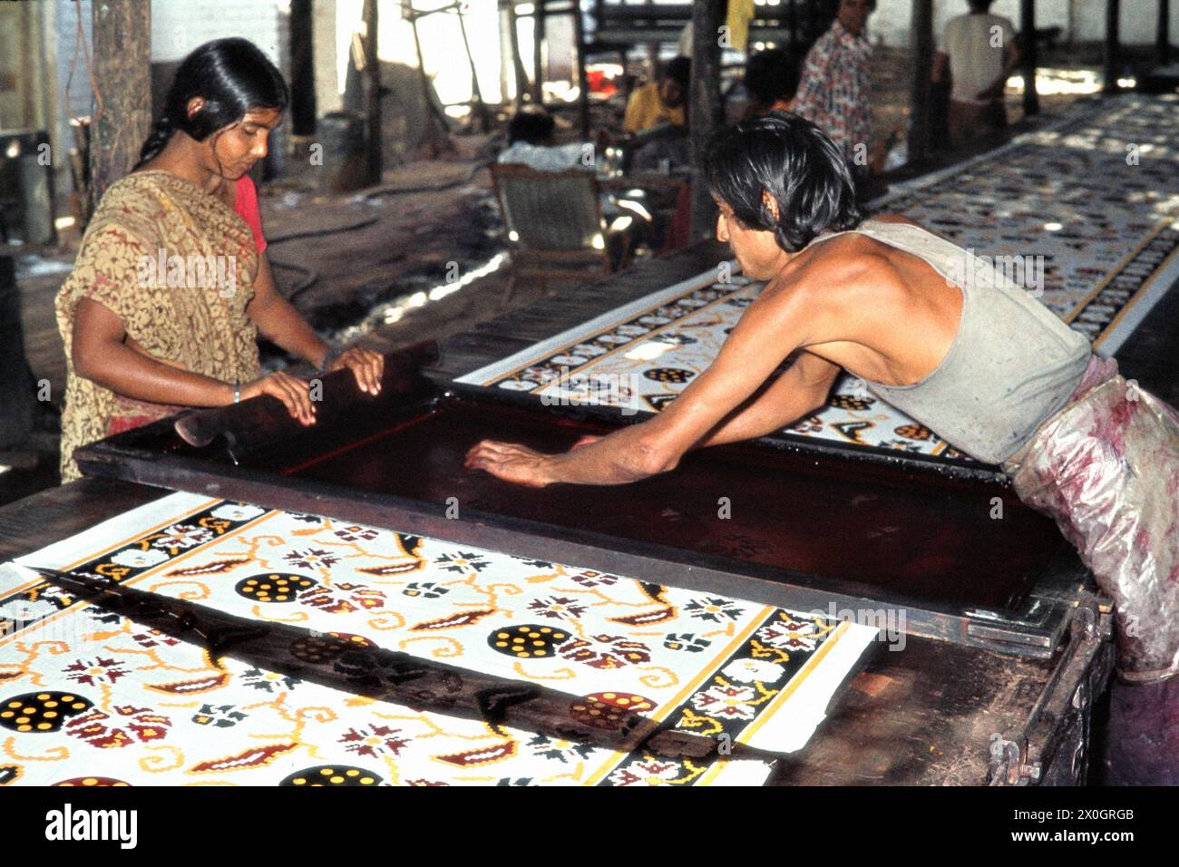 Un uomo e una donna al lavoro in una stampa tessile a Ahmedabad. [traduzione automatica] Foto Stock