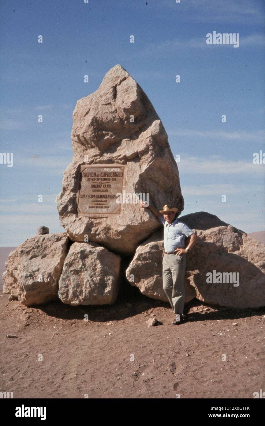 Il fotografo Czychowski di fronte ad una tavoletta di pietra a Latorre, che informa sul Tropico del cancro a questo punto. [traduzione automatica] Foto Stock