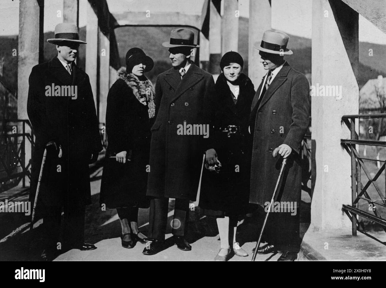 Donne con cappelli e cappotti e uomini con canne, cappelli e cappotti in gita. Foto Stock