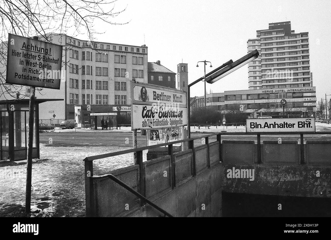 L'Anhalter Bahnhof di Berlino. A sinistra nell'immagine c'è un segno che dice "attenzione! Ecco l'ultima stazione della S-Bahn a Berlino Ovest in direzione di Potsdamer Platz'. Sullo sfondo ci sono dei grattacieli. Foto Stock
