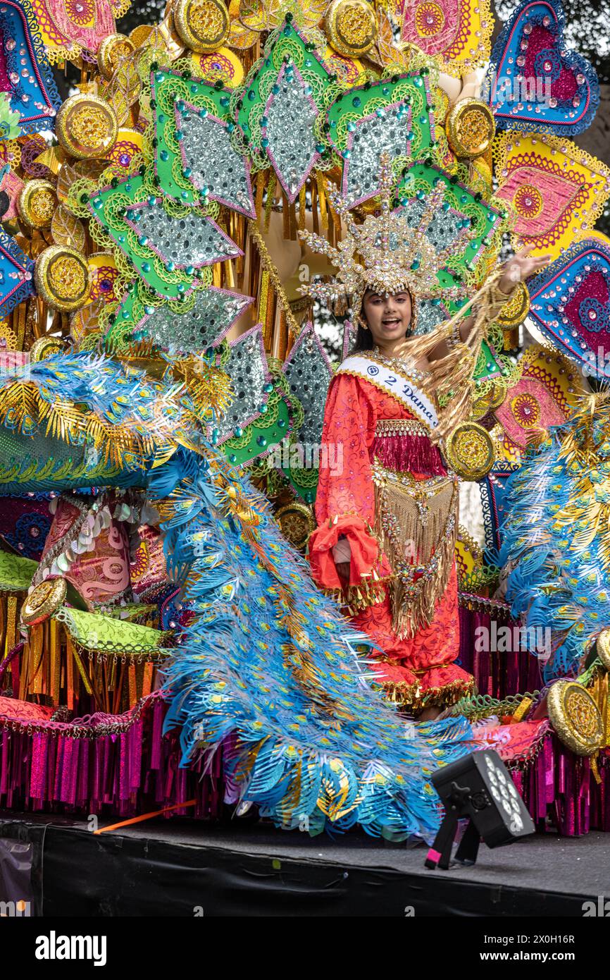 Ragazza in costume elaborato su enorme galleggiante decorato nella sfilata di Carnevale di tenerife, 2024 Foto Stock