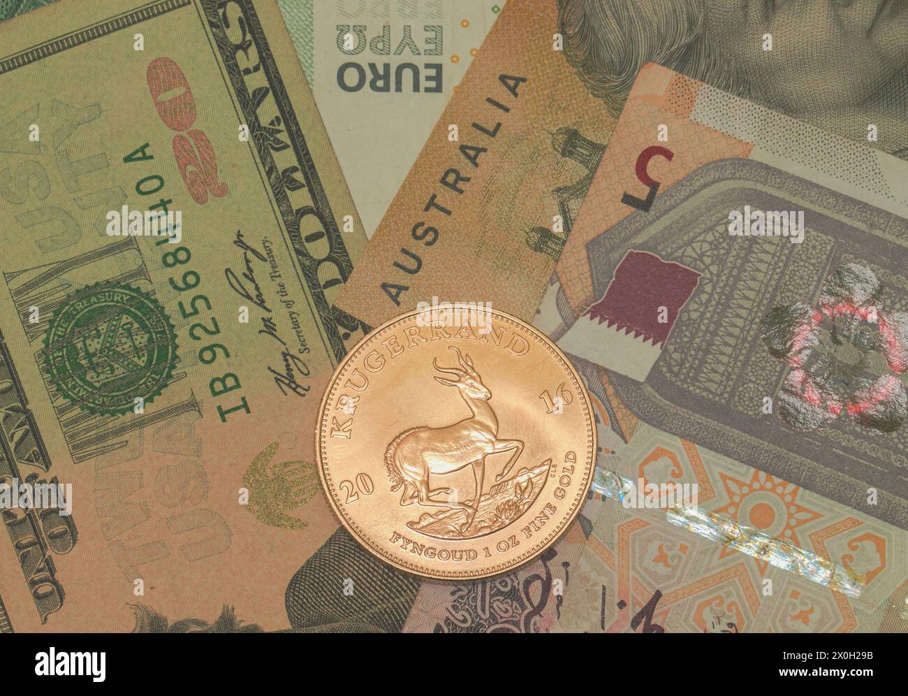 1 oncia originale moneta d'oro Kruger Rand sudafricana da 24 carati contro diverse comuni valute di carta fiat; dollaro, euro, riyal aud; anti-inflazione Foto Stock