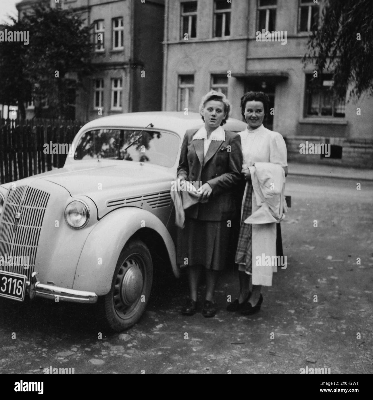 Due donne di fronte ad una nuova auto a Sundern. Foto Stock