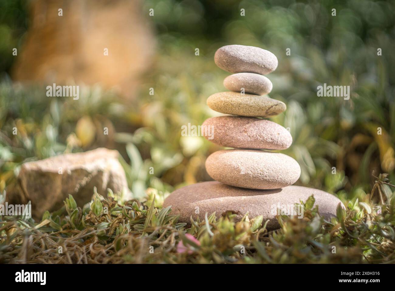 6 pietre che si bilanciano l'una sull'altra per creare una torre di pietre per la meditazione e il riposo nella natura Foto Stock