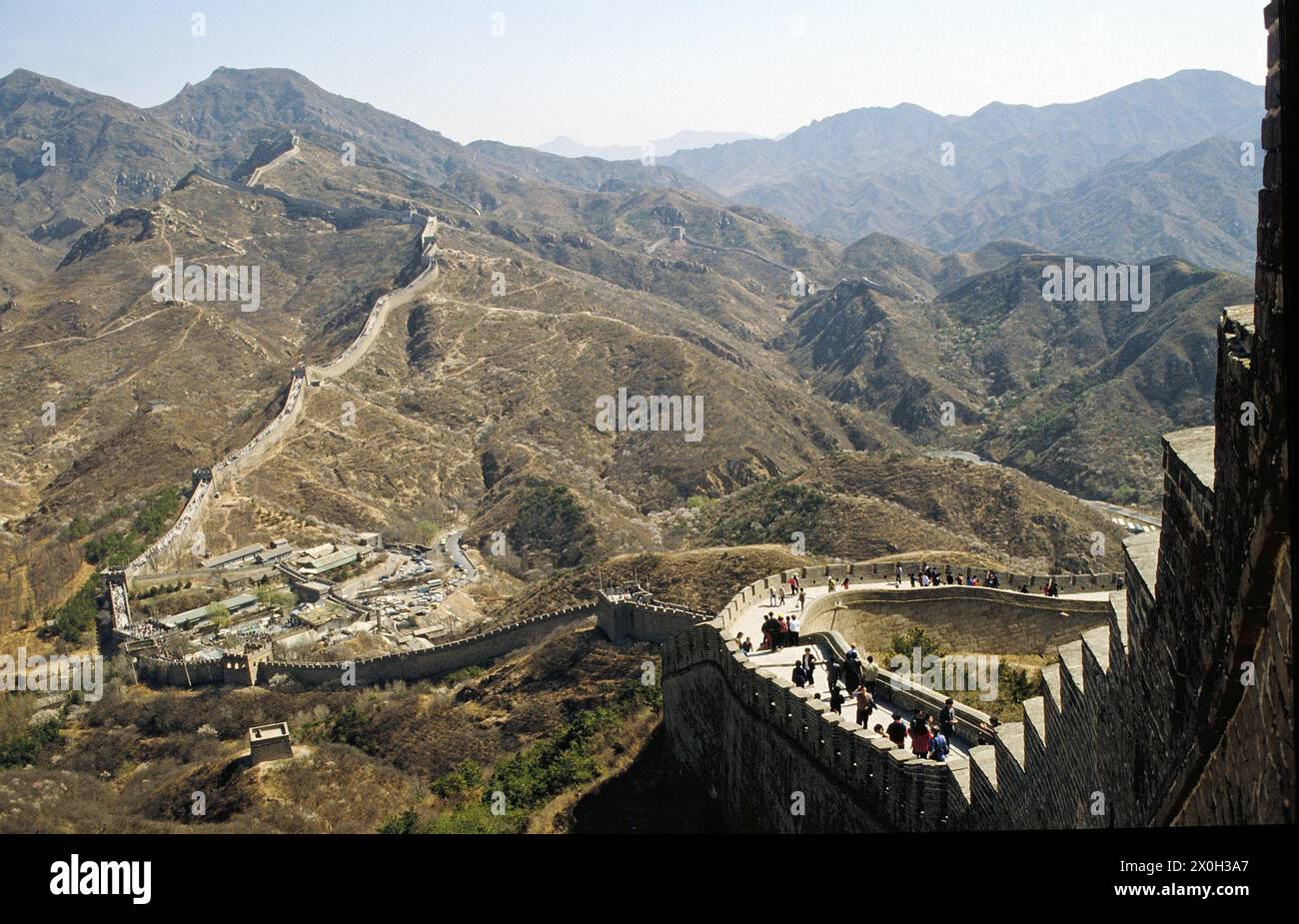 Turisti sulla Grande Muraglia Cinese a Badaling vicino Pechino. Nel paesaggio di sfondo e montagne. [traduzione automatica] Foto Stock