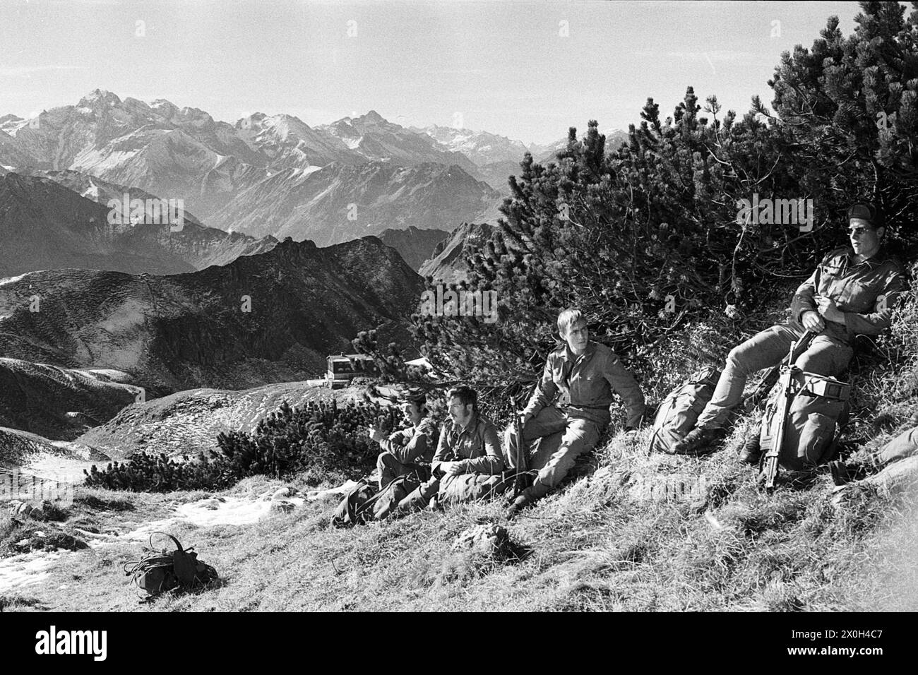 All'ombra dei pini di montagna, i soldati aspettano di marciare. [traduzione automatizzata] Foto Stock