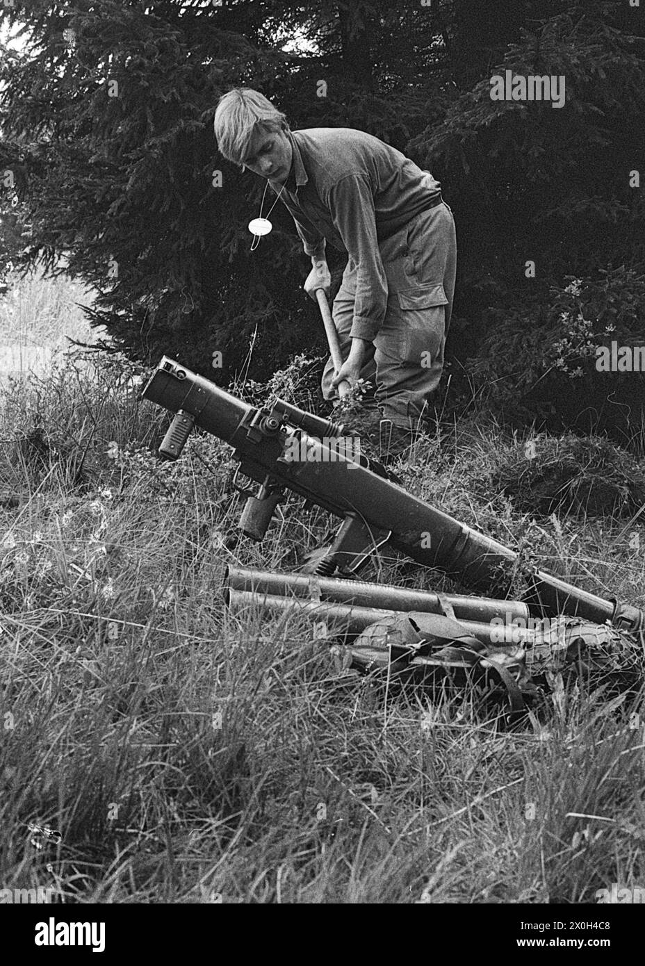 Esercitazione delle truppe: Un soldato costruisce la sua posizione. I pesanti bazooka e i contenitori di munizioni sono pronti a portata di mano. [traduzione automatizzata] Foto Stock