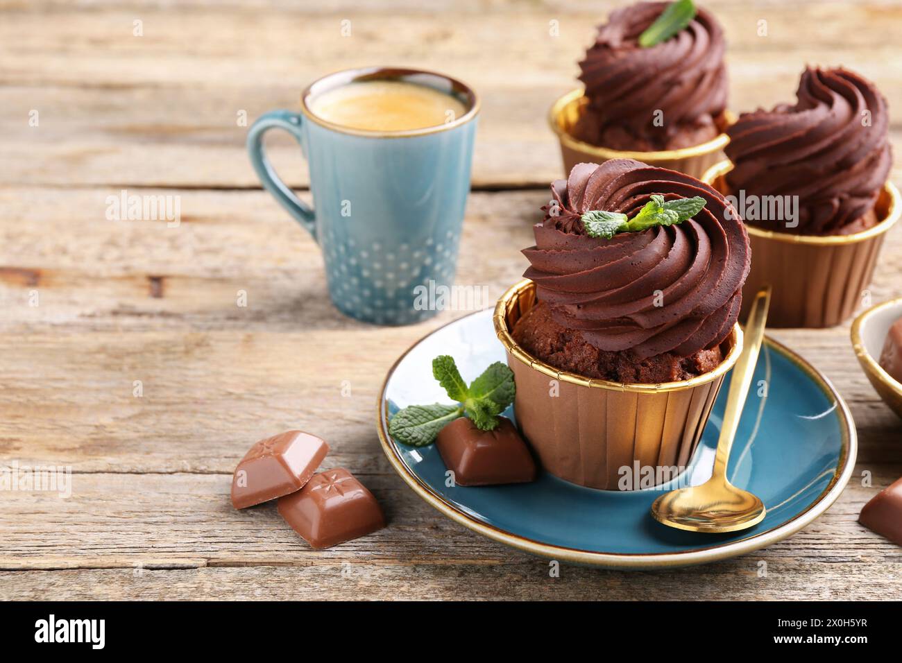 Deliziosi cupcake con pezzi di menta e cioccolato su un tavolo di legno. Spazio per il testo Foto Stock