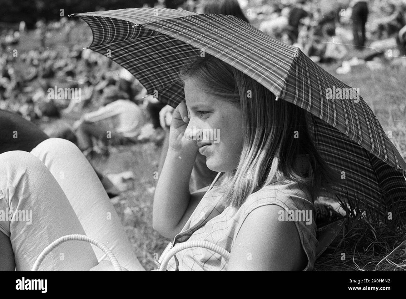 Una giovane donna si protegge dal sole con un ombrello. Foto di un festival al Thingstätte di Heidelberg, 1970. [traduzione automatizzata] Foto Stock