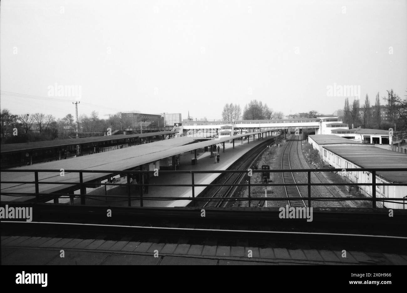 Nell'aprile 1992, solo poche persone sospettarono che la conversione in una stazione direzionale, che era stata pianificata per decenni, potesse essere effettuata senza interrompere le operazioni. Di conseguenza, la stazione cadde in rovina e divenne una croce di ruggine, come era popolarmente conosciuta. La foto è stata presa dalla piattaforma dell'anello. Sulla destra si trovano i binari per Wriezener Bahnhof e RAW Warschauerstrasse. Poi le due piattaforme verso Straußberg a destra e Erkner a sinistra. Sul retro si trova il famoso ponte pedonale, che collega tutte le piattaforme, compresa la piattaforma quasi irriconoscibile Foto Stock