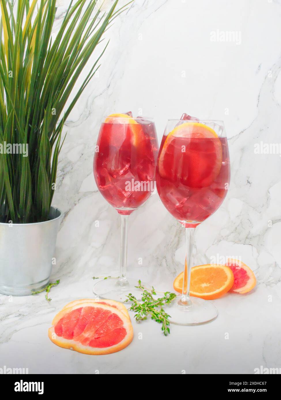Spritzer all'arancia rossa con arance rosse a fette e fette di arance e timo Foto Stock