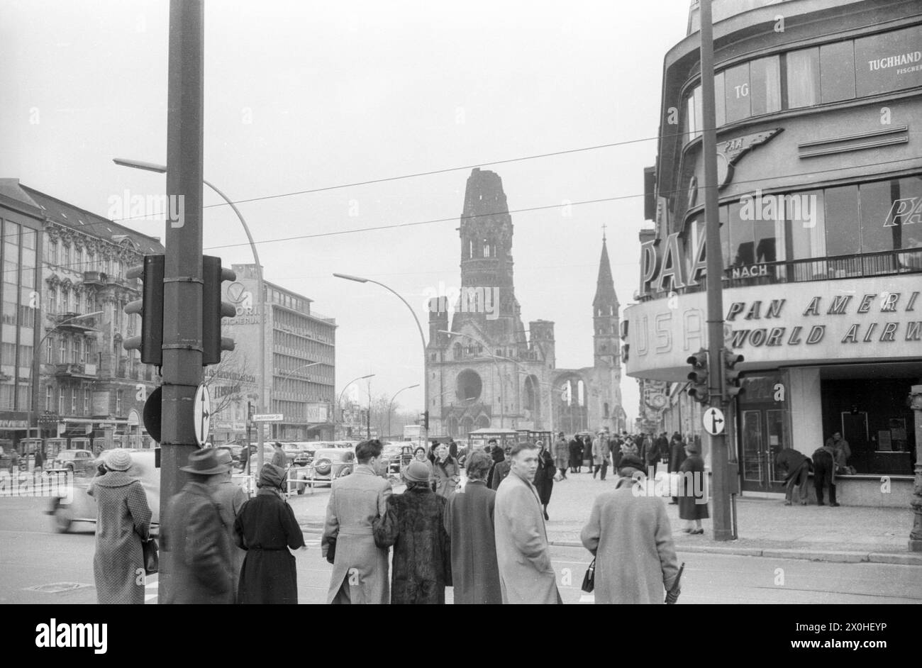 All'incrocio tra Ku'damm e Joachimstaler Strasse, i passanti aspettano al semaforo per attraversare la strada. Al centro dell'immagine si trovano le rovine della Memorial Church. [traduzione automatizzata] Foto Stock