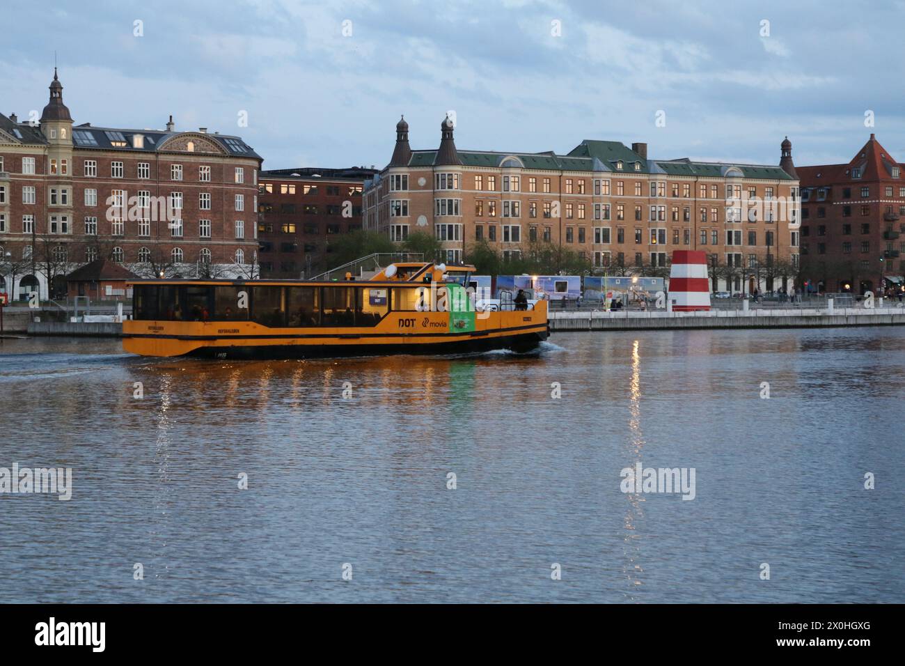 Autobus giallo al crepuscolo nel porto di Copenaghen, Danimarca, aprile 2024 Foto Stock