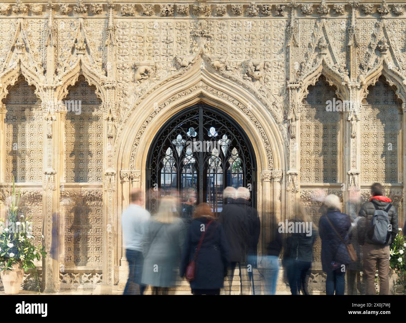 I turisti di fronte all'ingresso attraverso il cordone in pietra decorato che conduce al coro della cattedrale di Lincoln, in Inghilterra. Foto Stock
