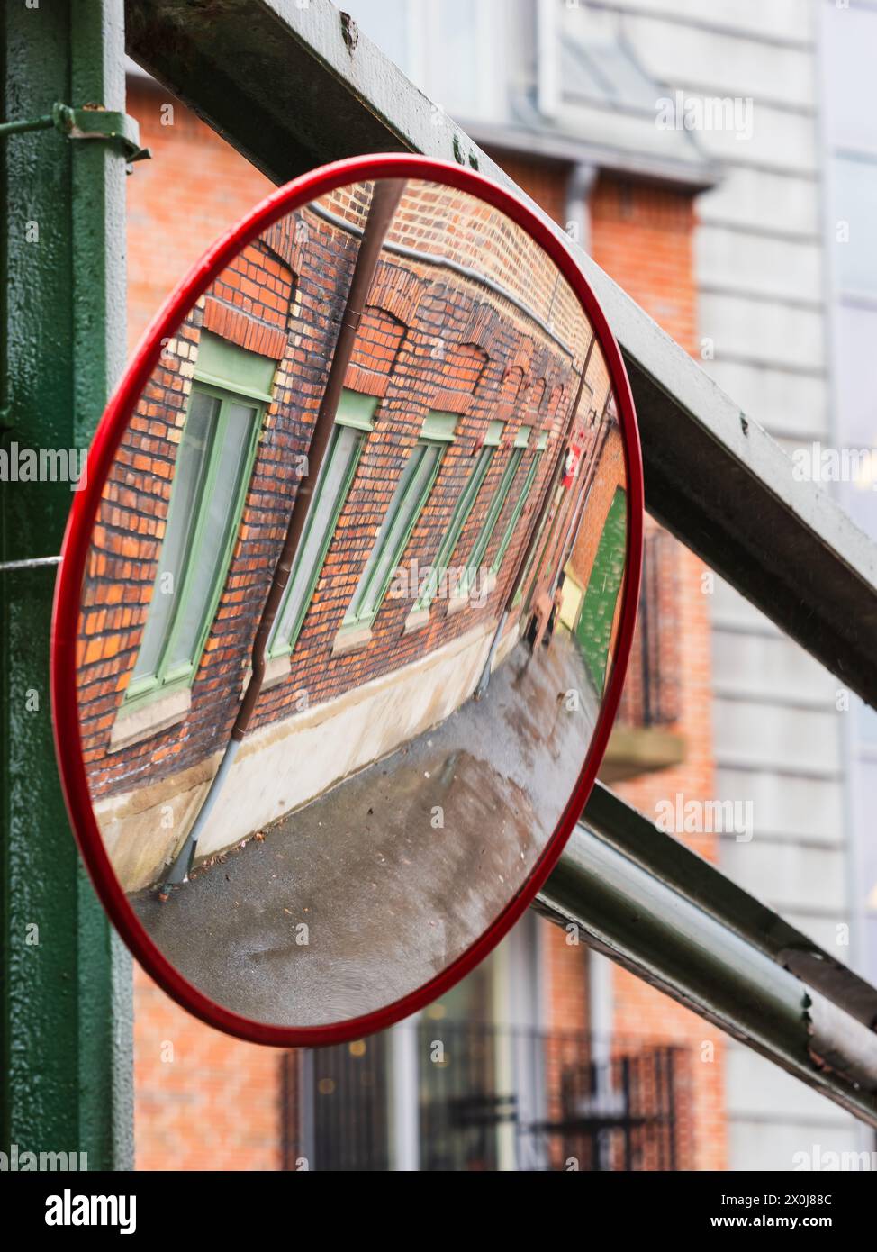 Uno specchio posto su una strada trafficata a Gothenburg, Svezia, riflette l'immagine di una facciata moderna di un edificio. Lo specchio cattura i dettagli architettonici Foto Stock
