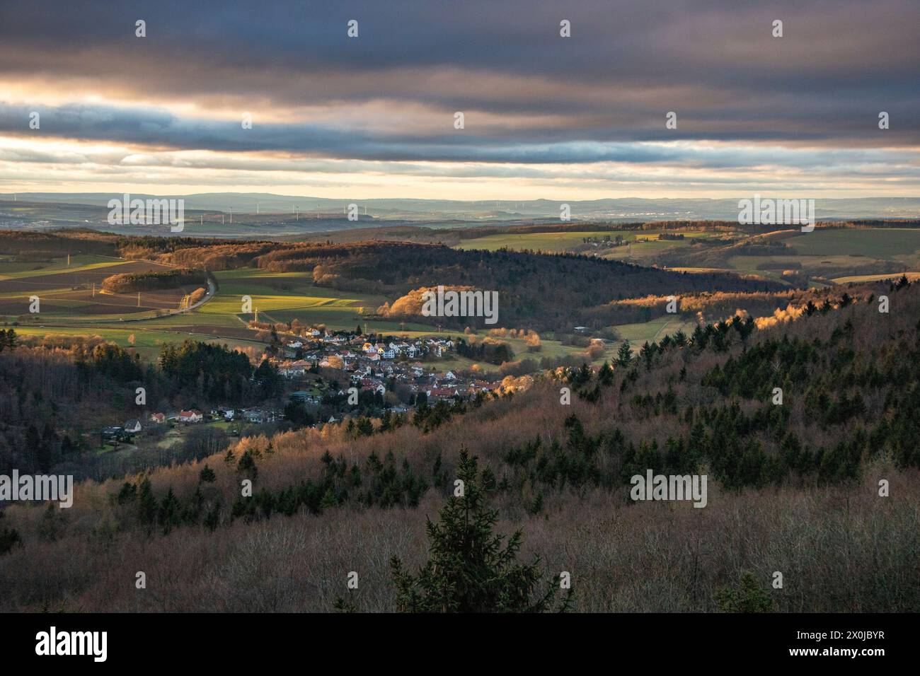 Paesaggio a Großer Zacken, regione vulcanica di Taunus. Una giornata autunnale nuvolosa e soleggiata, prati, colline, campi e foreste con vista sul tramonto. Assia, Germania Foto Stock