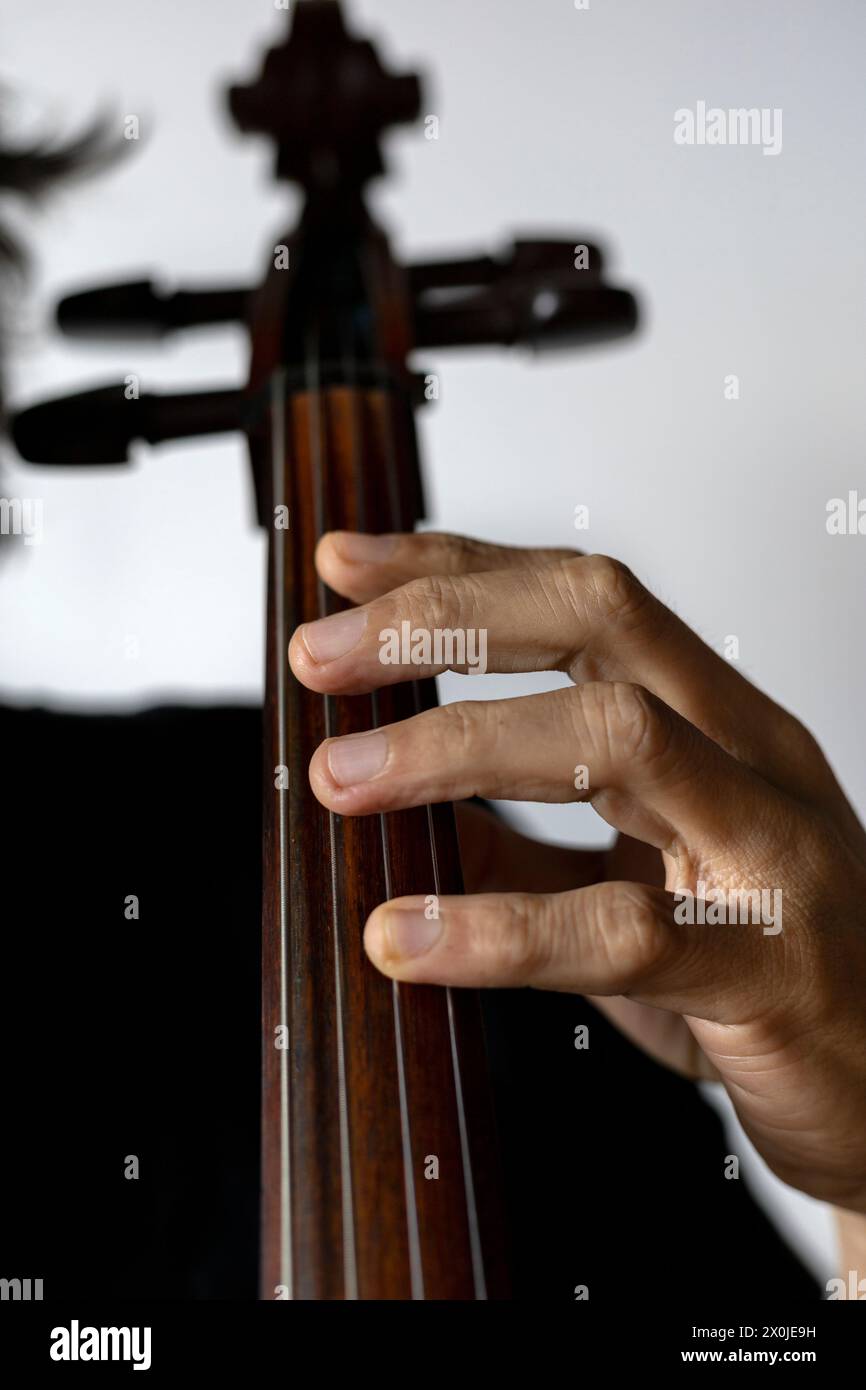 Primo piano della mano correttamente posizionato in prima posizione sul violoncello. Concept orchestra strumento e studente di musica. Foto Stock