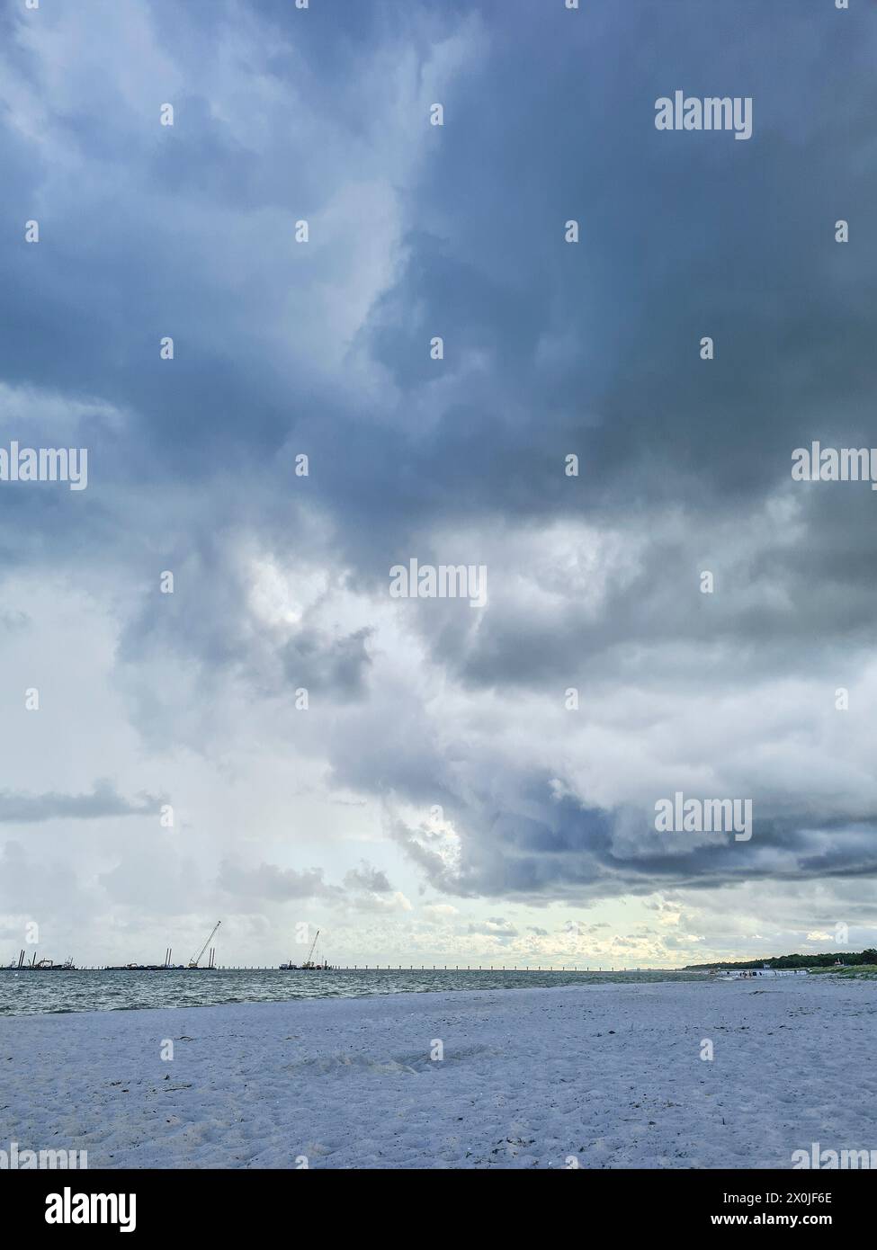 Germania, Meclemburgo-Pomerania occidentale, Prerow, formazione di nuvole sulla spiaggia della costa del Mar Baltico, vista sulla spiaggia vuota fino all'orizzonte Foto Stock