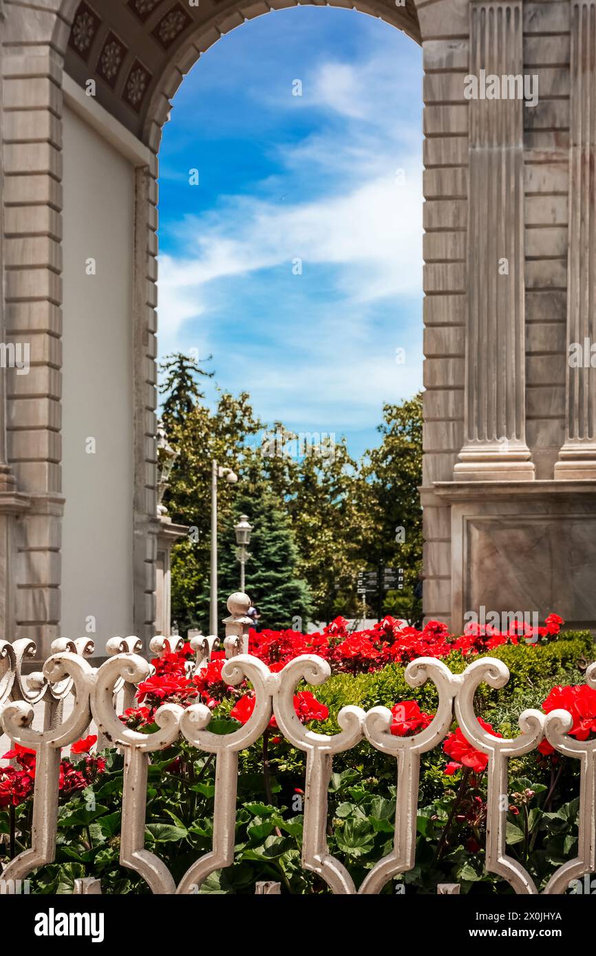 Il lussureggiante giardino di gerani rossi che accompagna i visitatori all'ingresso del maestoso Palazzo Dolmabahce di Istanbul Foto Stock