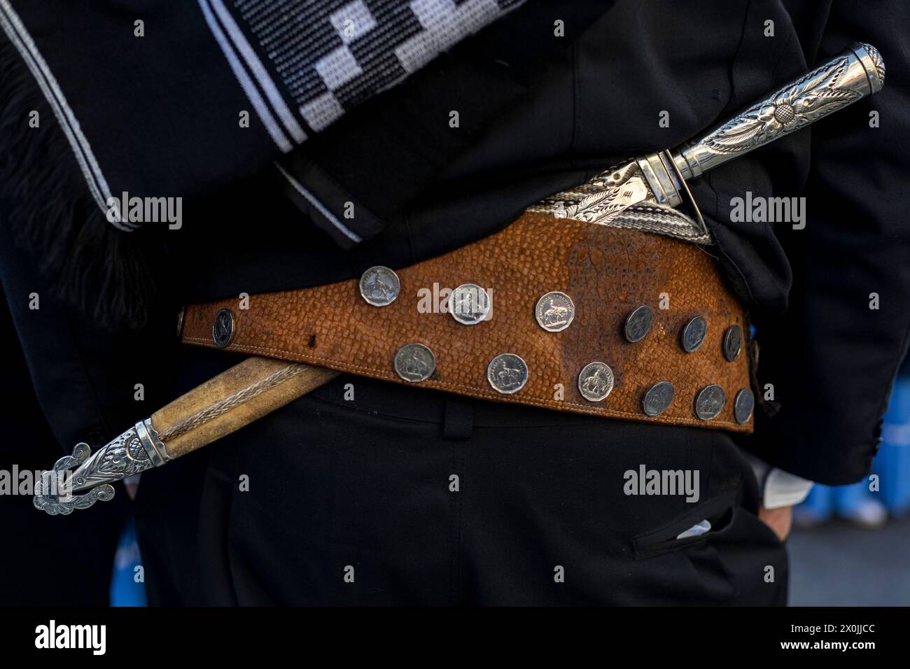 Vista posteriore in dettaglio del nastro tradizionale e del coltello (facon) di un gaucho argentino. Primo piano, persona irriconoscibile. Concetto di cultura argentina e T Foto Stock