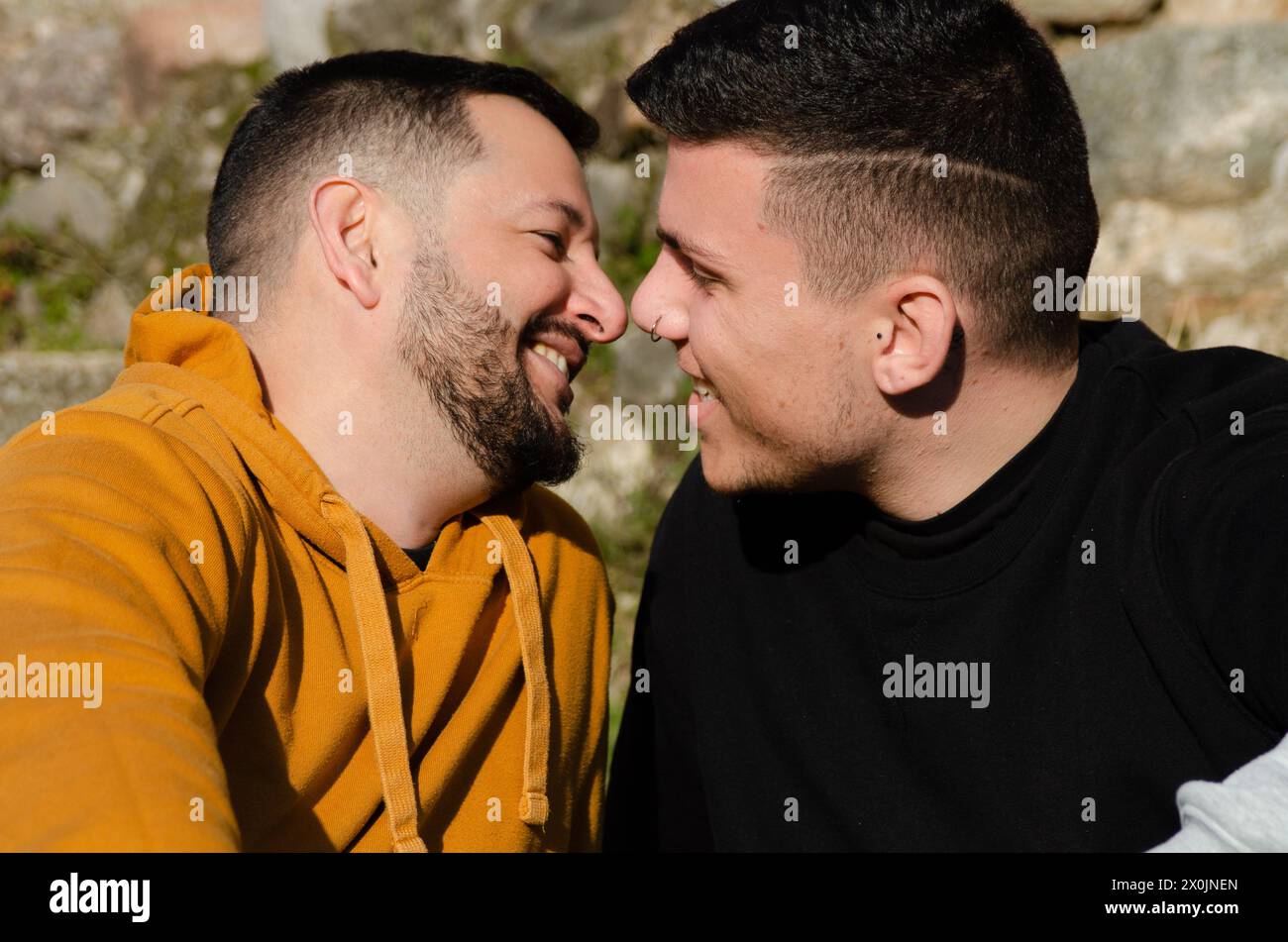 Gli uomini gay si sposano in amore sorridendo l'un l'altro prima di baciarsi. Omosessualità e concetto LGBTIQ+. Foto Stock