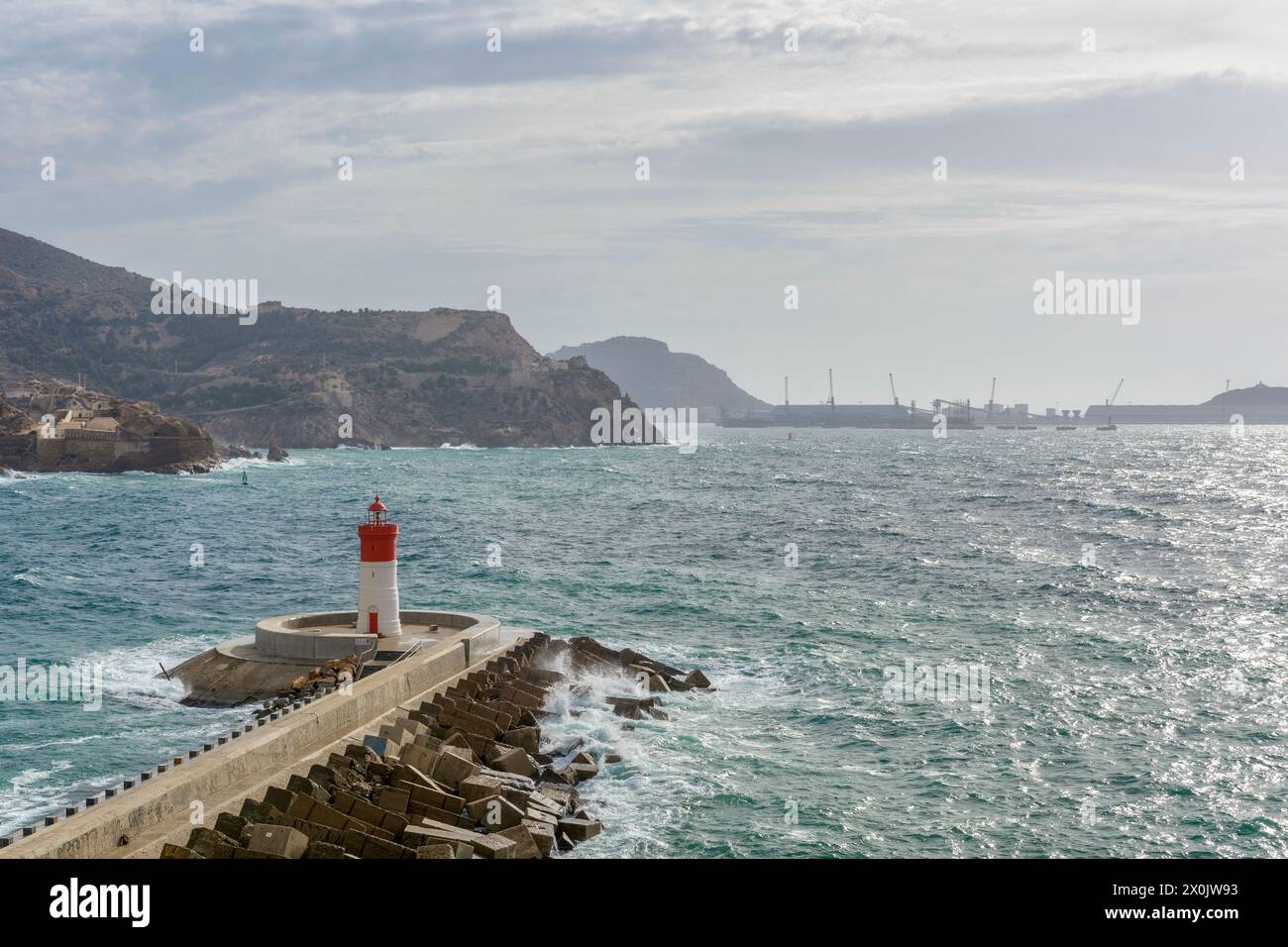 Il faro rosso della banchina di Natale sul frangiflutti per la difesa contro il vento sud-est della baia nel porto di Cartagena, Spagna, Europa Foto Stock