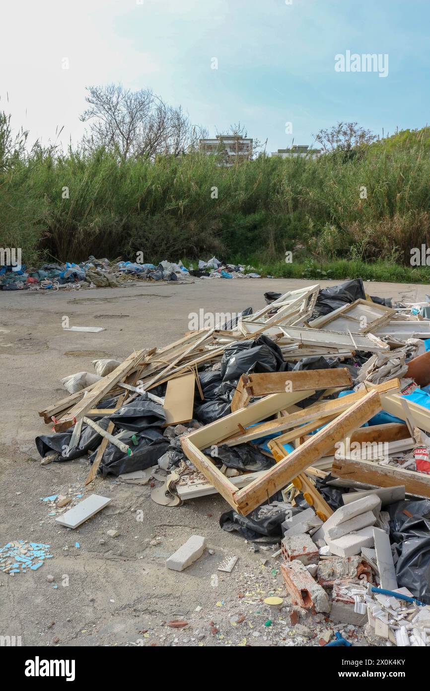 Immergiti nel paesaggio inquietante del degrado urbano e del degrado ambientale con questa suggestiva immagine di una montagna di rifiuti in una fabbrica abbandonata Foto Stock