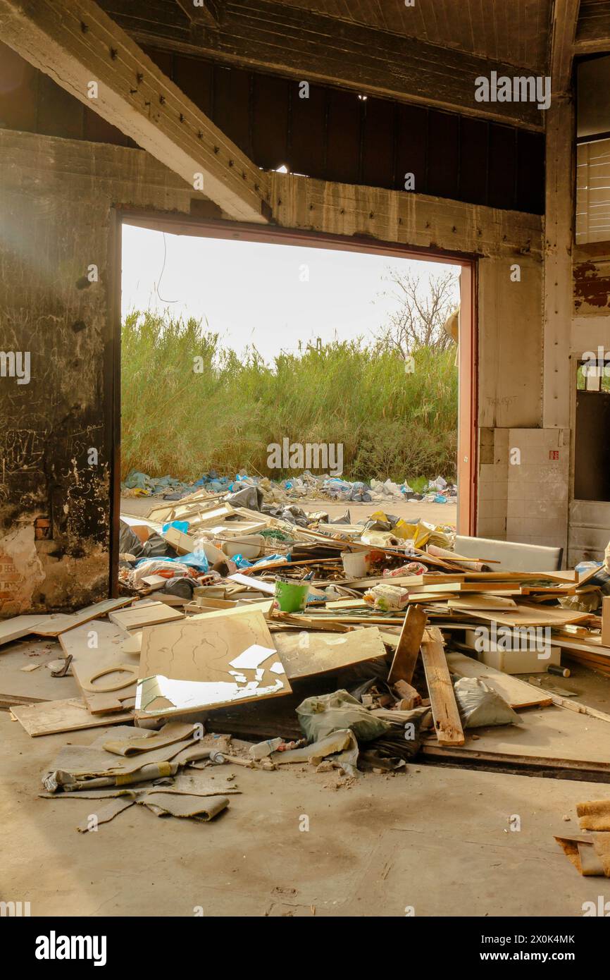 Immergiti nel paesaggio inquietante del degrado urbano e del degrado ambientale con questa suggestiva immagine di una montagna di rifiuti in una fabbrica abbandonata Foto Stock