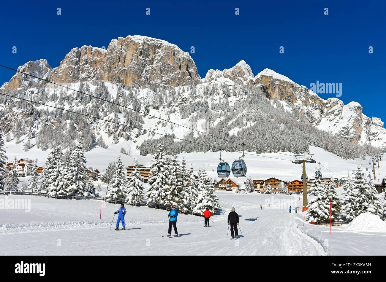 Sciatori in discesa alla stazione a valle della funivia di Colfosco, Colfosco, Corvara, regione degli sport invernali dell'alta Badia, Dolomiti, alto Adige, Italia Foto Stock