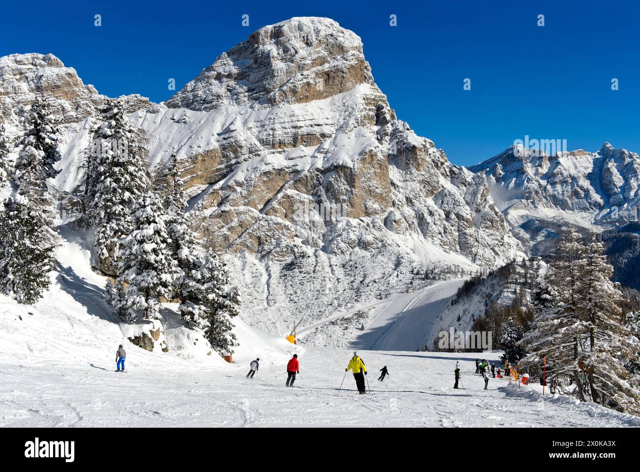 Sciatori su una pista nella località di sport invernali di Colfosco, Colfosco, ai piedi della vetta Sassongher, nel comprensorio sciistico dell'alta Badia, Dolomiti, alto Adige, Italia Foto Stock