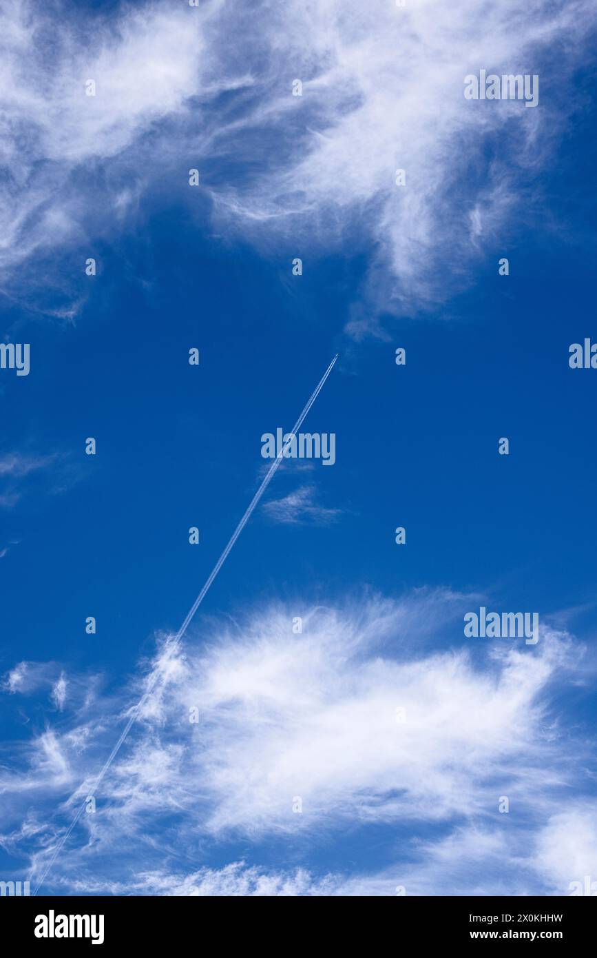 Le nuvole di Cirrus stropicciate dal vento nel cielo blu, i contrasti degli aerei di passaggio Foto Stock