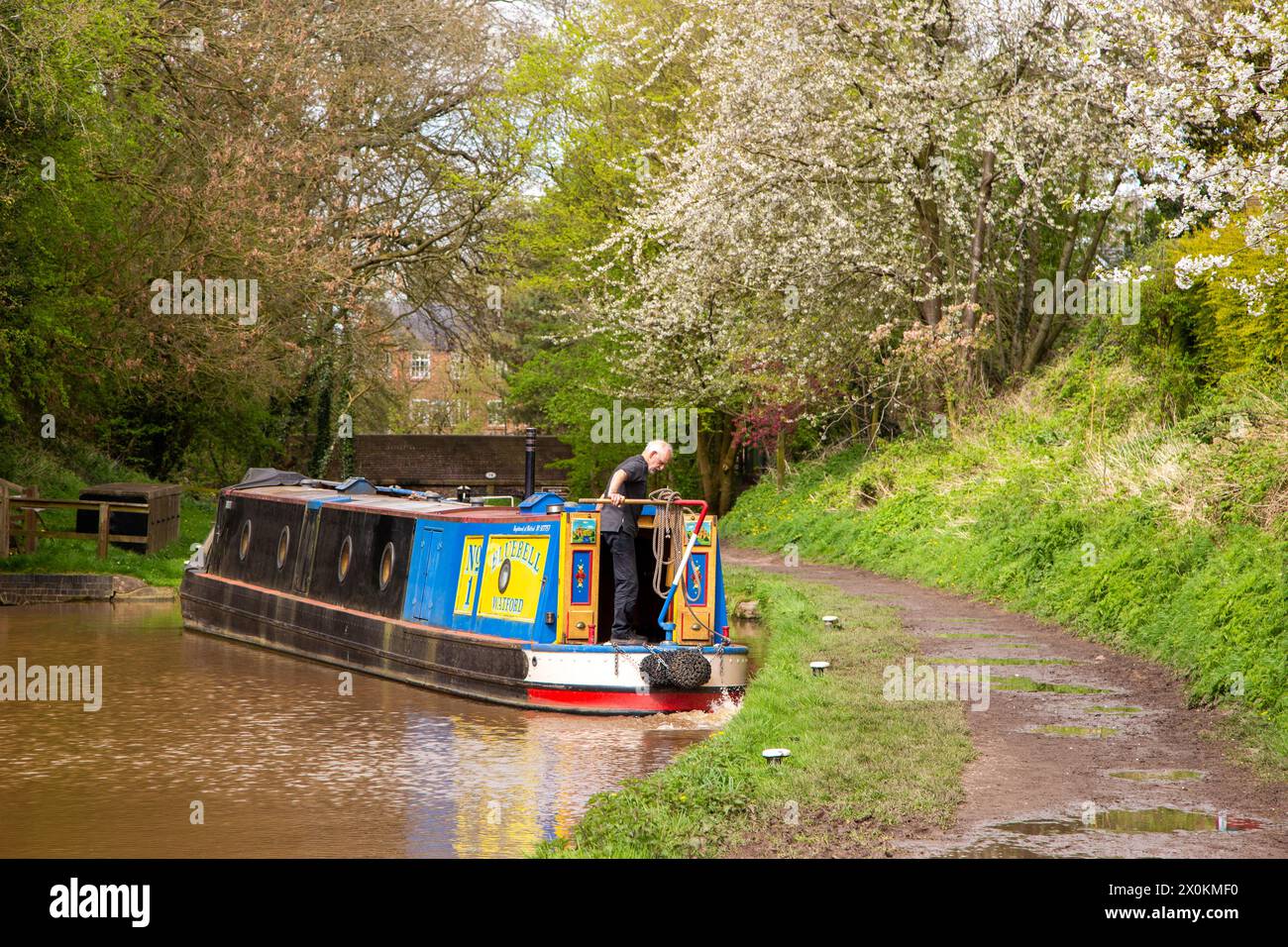 Uomo che prende un canale in barca stretta da solo attraverso chiuse sul canale Shropshire union mentre si avvicina al villaggio Cheshire di Audlem, Inghilterra, Regno Unito Foto Stock
